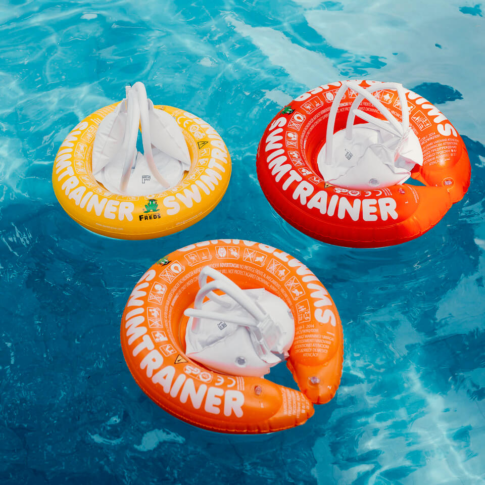 Vue des 3 bouées Swimtrainer classiques rouge, orange et jaune dans une piscine.